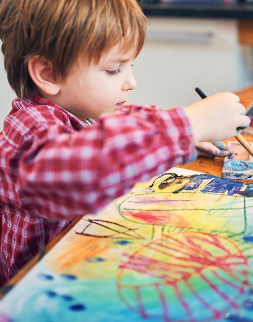 Cute happy little boy, adorable preschooler, painting in a sunny art studio. Young artist at work.